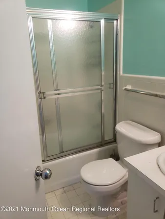 a white toilet sitting next to a shower