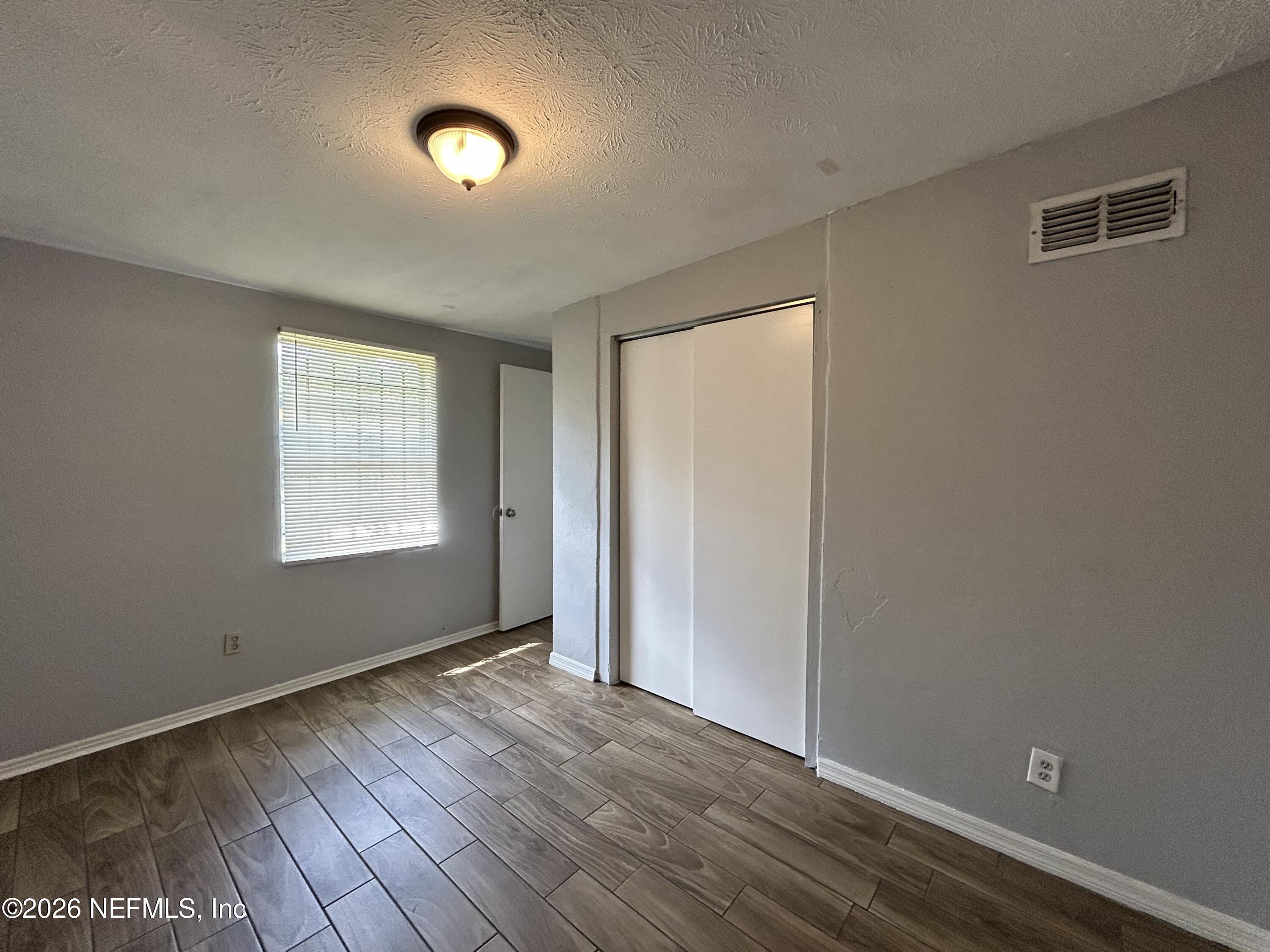 3250 Phyllis Street Jacksonville, FL 32205 - Photo 8 of 9 an empty room with wooden floor and windows