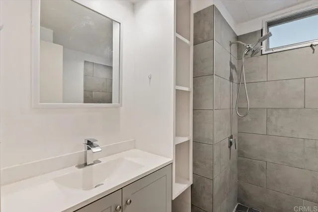a bathroom with a sink vanity granite and shower