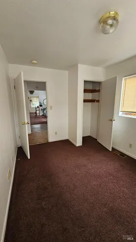 a view of empty room with kitchen and window