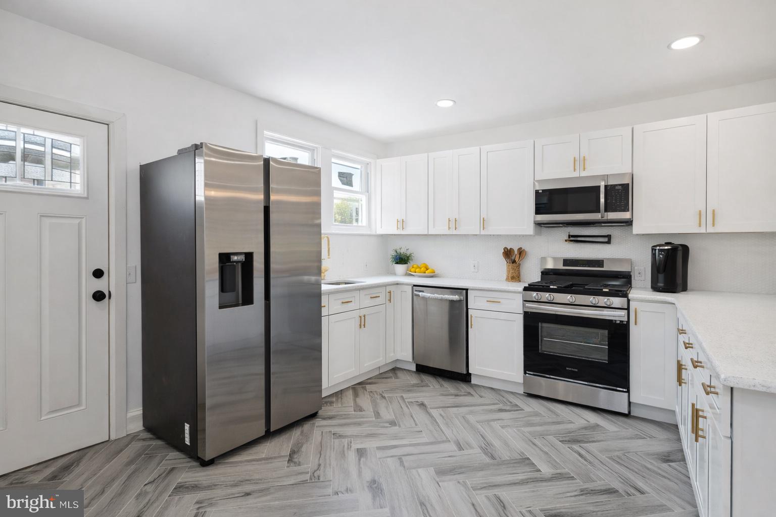 2414 77th Avenue Philadelphia, PA 19150 - Photo 7 of 25 a kitchen with a refrigerator sink and cabinets