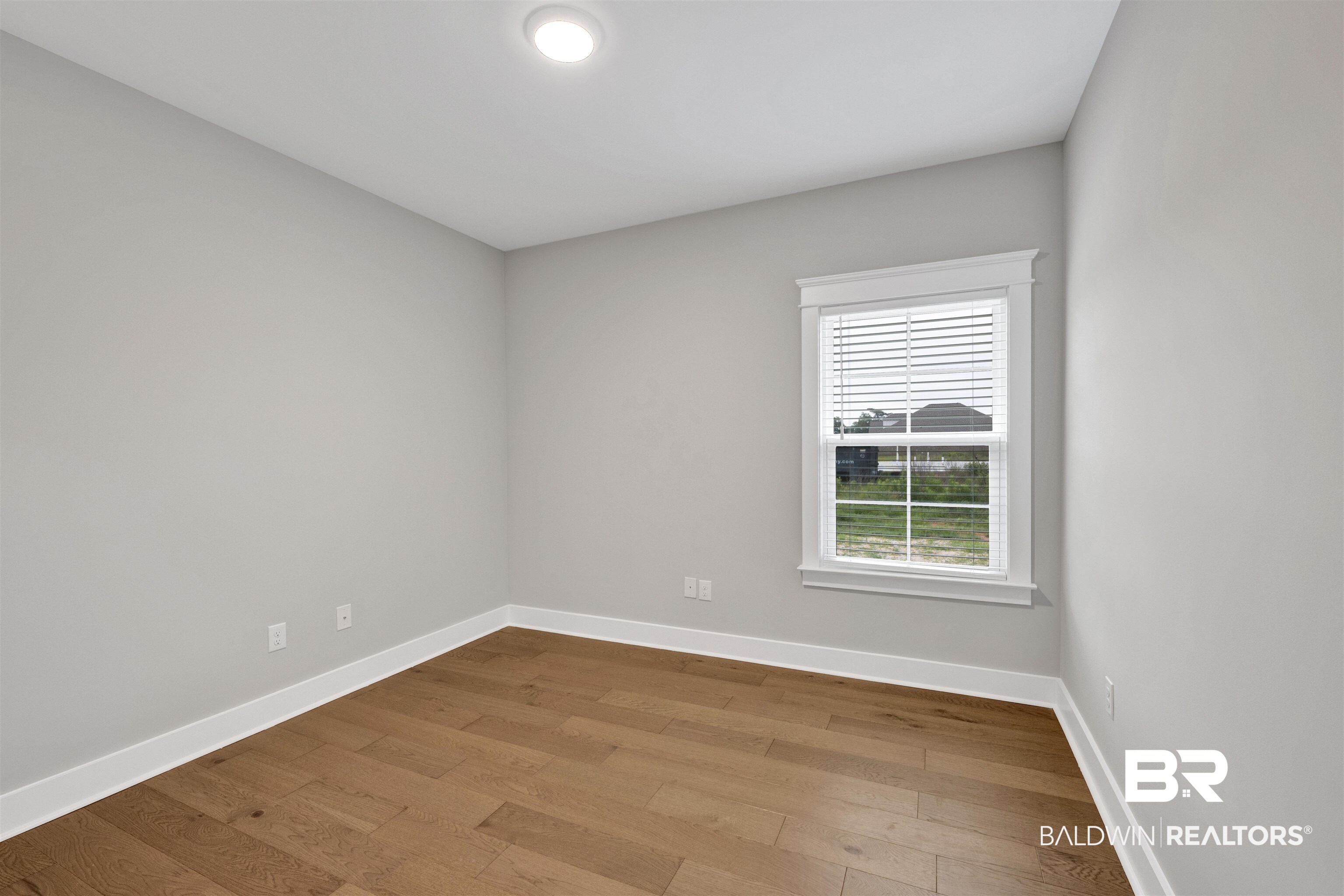 27371 Patch Pl Loop Daphne, AL 36526 - Photo 50 of 63 Light-filled room featuring wood-finish flooring, white baseboards, and a single window with white blinds
