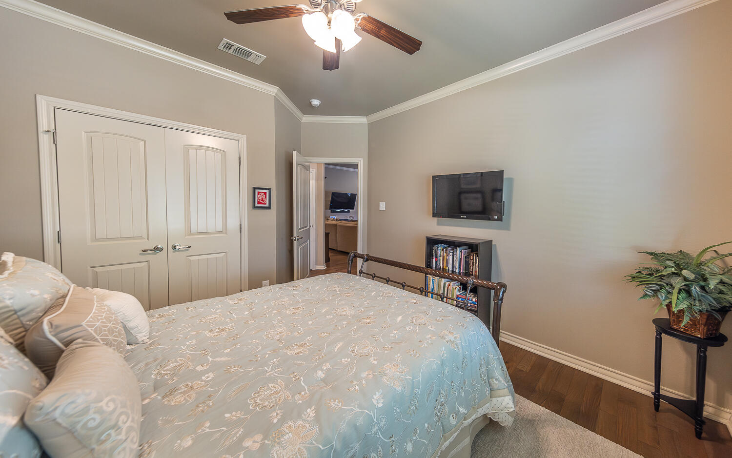 4402 108th Street, Unit 10 Lubbock, TX 79424 - Photo 16 of 21 a spacious bedroom with a bed and a potted plant on the dresser