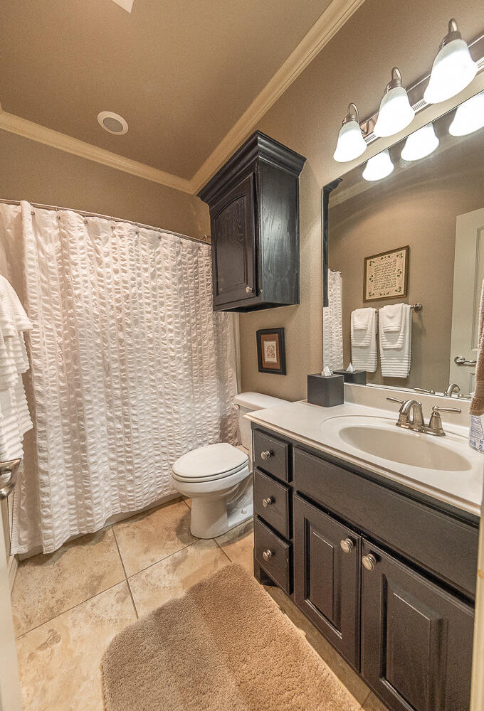 4402 108th Street, Unit 10 Lubbock, TX 79424 - Photo 17 of 21 a bathroom with a toilet a sink and mirror