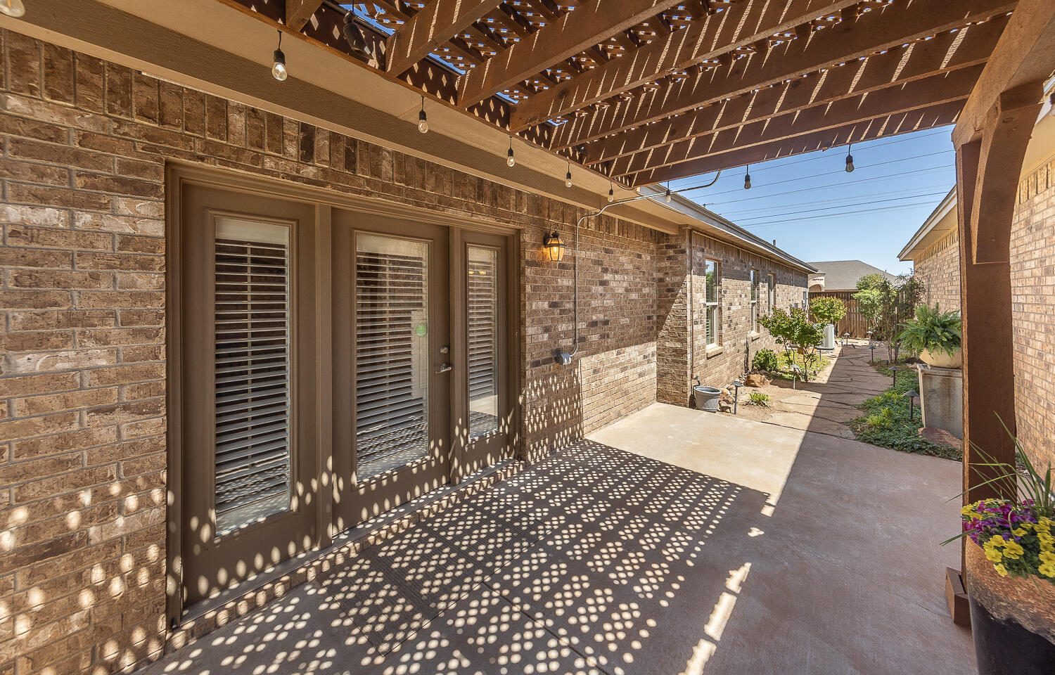 4402 108th Street, Unit 10 Lubbock, TX 79424 - Photo 19 of 21 a view of a patio with a table and chairs and potted plants