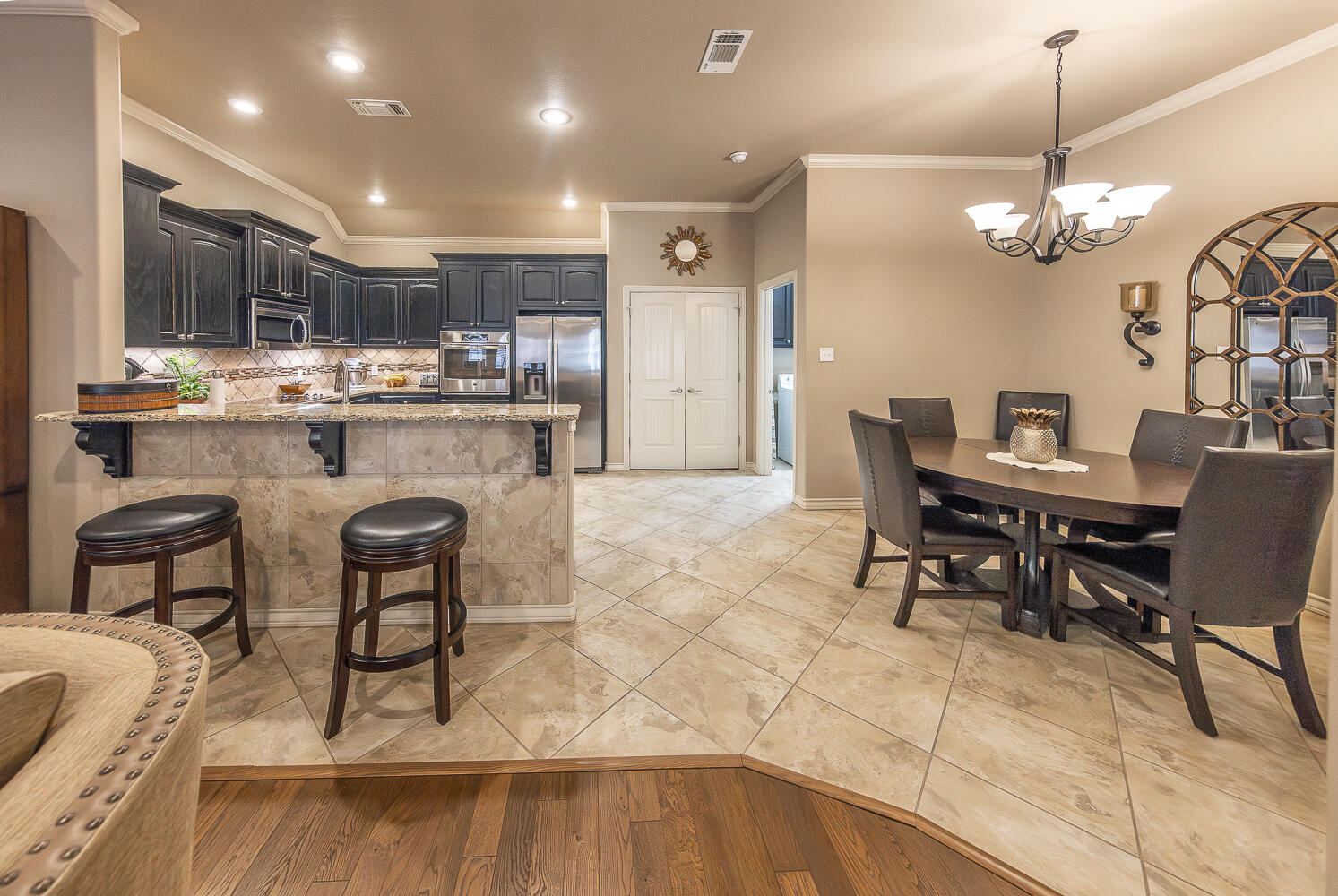 4402 108th Street, Unit 10 Lubbock, TX 79424 - Photo 6 of 21 a kitchen with kitchen island a dining table chairs and white cabinets