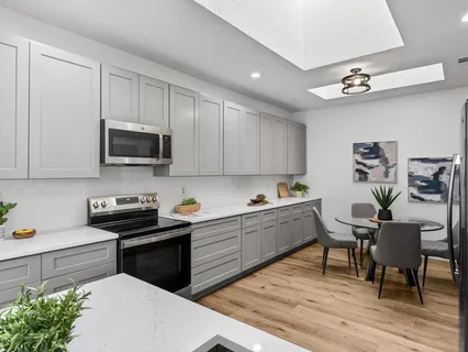 a kitchen with stainless steel appliances granite countertop a sink dishwasher a stove a microwave oven with cabinets and wooden floor