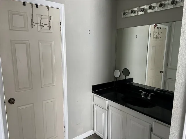 a close view of a sink a mirror and cabinets