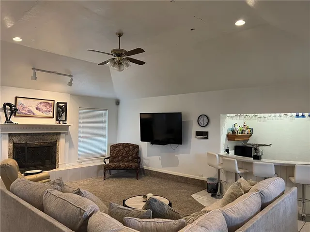a living room with furniture a fireplace and a flat screen tv