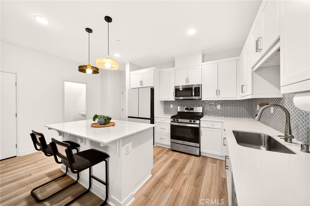35165 Rangpur Lane Fallbrook, CA 92028 - Photo 11 of 42 a kitchen with stainless steel appliances kitchen island a table chairs microwave and sink