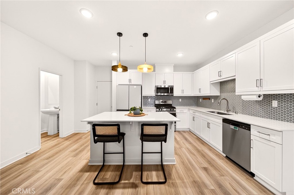 35165 Rangpur Lane Fallbrook, CA 92028 - Photo 10 of 42 a kitchen with stainless steel appliances granite countertop a stove a sink dishwasher and a refrigerator with wooden floor