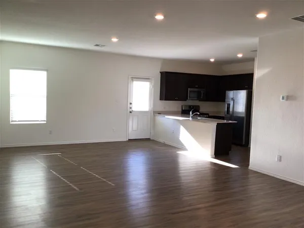 a view of a small space with wooden floor and a window