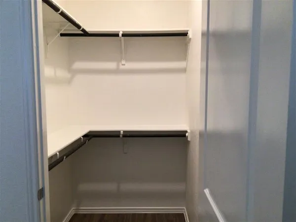 a view of a hallway with wooden floor and closet