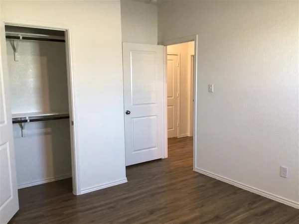 an empty room with wooden floor and closet