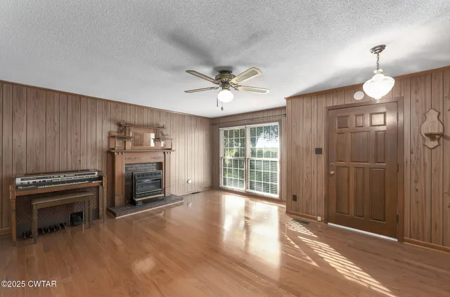 a view of an empty room with a fireplace and a window
