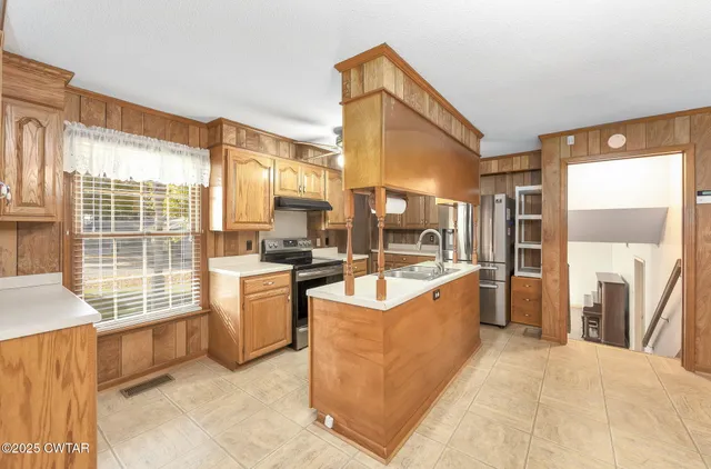 a large white kitchen with a large window
