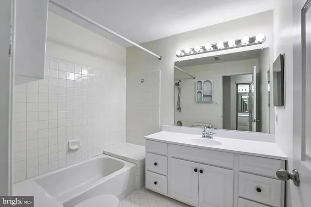 a bathroom with a double vanity sink mirror and bathtub