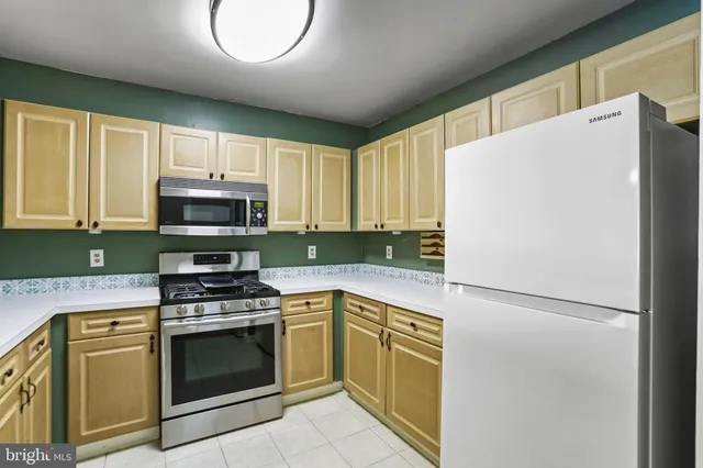 a kitchen with cabinets stainless steel appliances and a window