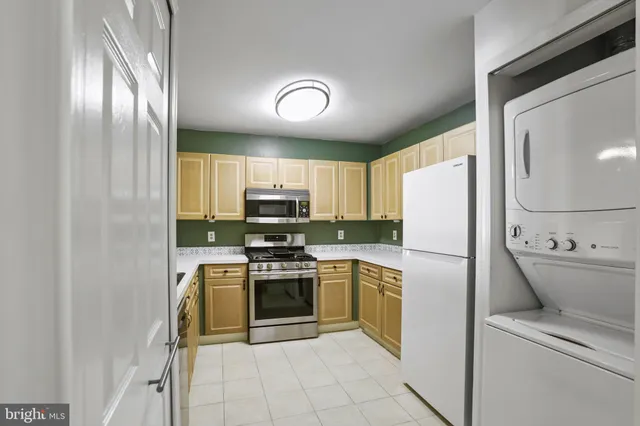 a kitchen with a refrigerator a stove top oven and cabinets