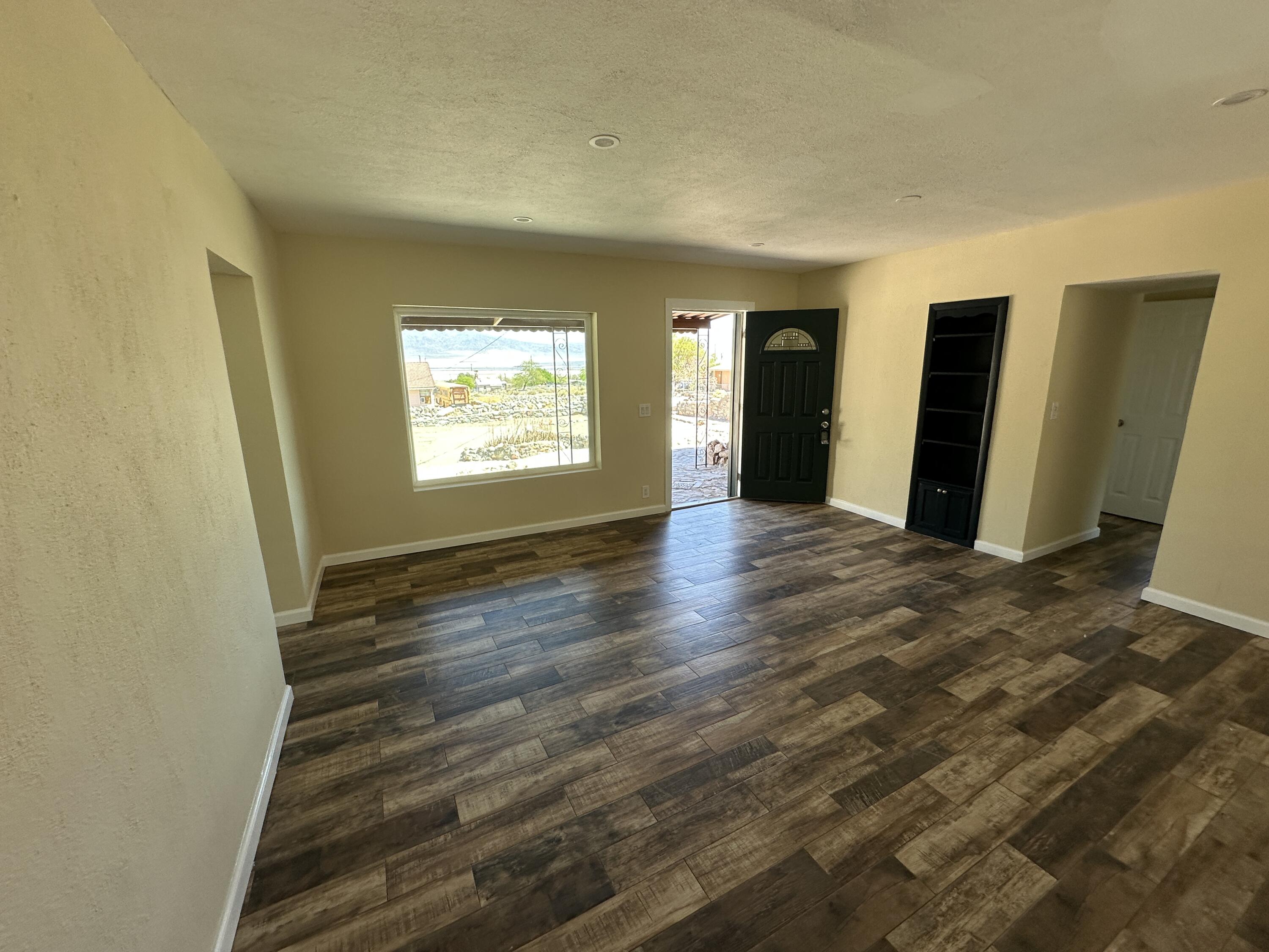 12164 B Street Trona, CA 93562 - Photo 5 of 41 an empty room with wooden floor and windows