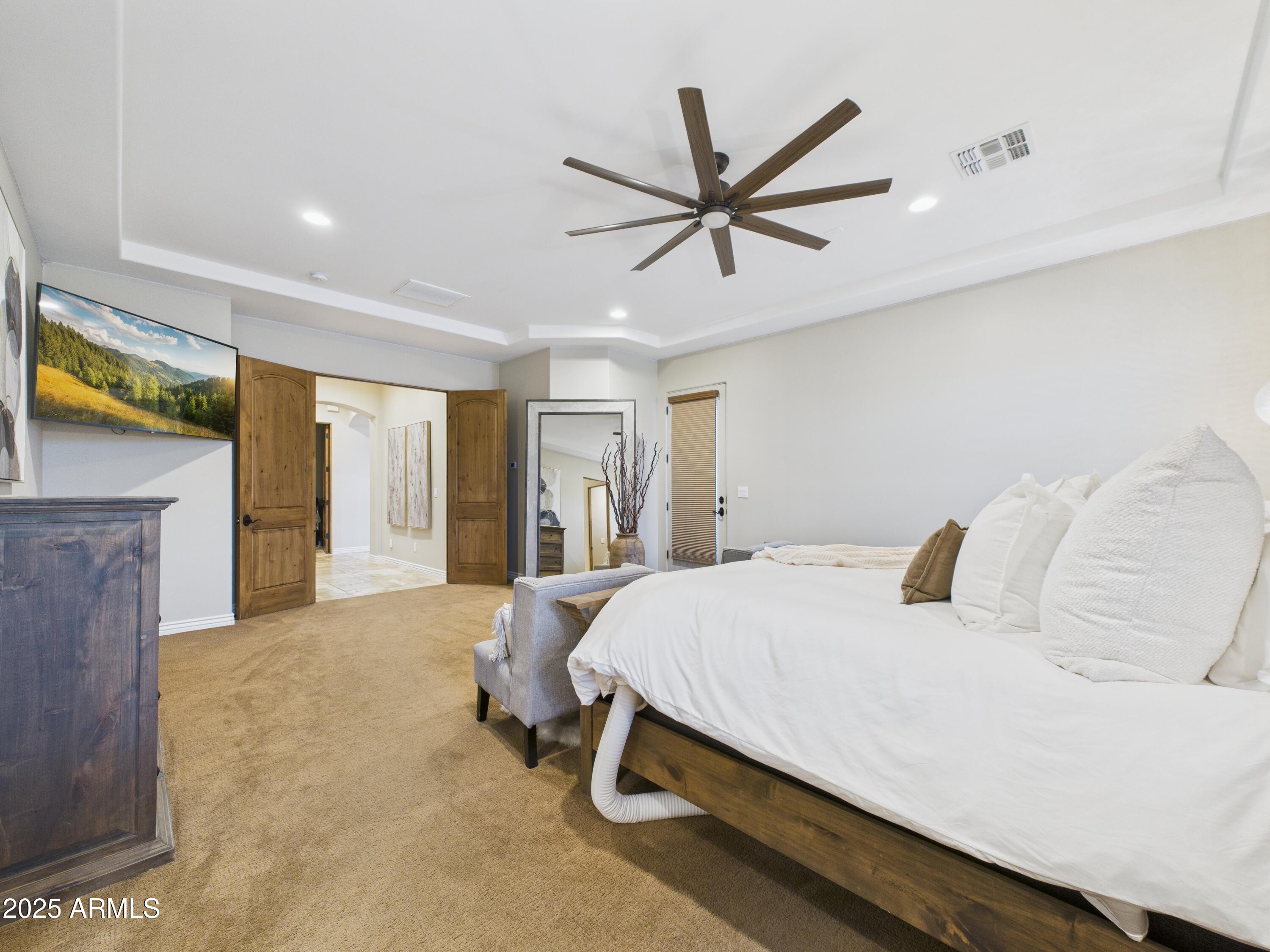 806 West Desert Ranch Road Phoenix, AZ 85086 - Photo 17 of 36 a bedroom with a bed and a chandelier