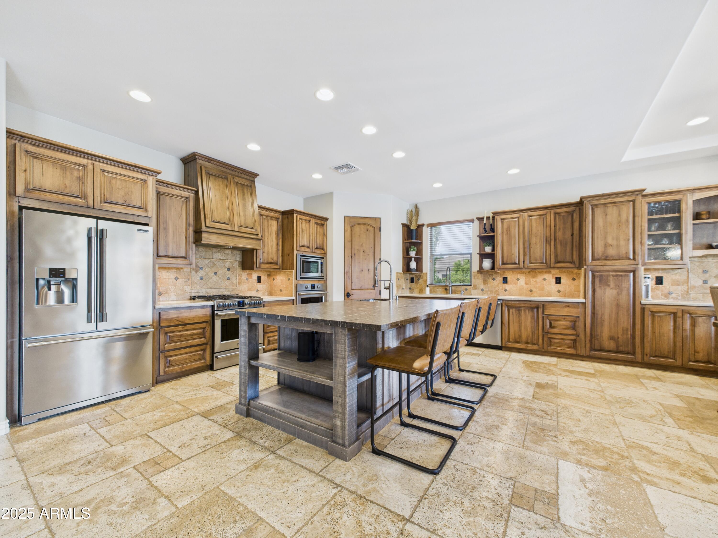806 West Desert Ranch Road Phoenix, AZ 85086 - Photo 32 of 36 a kitchen with stainless steel appliances kitchen island granite countertop a refrigerator and cabinets