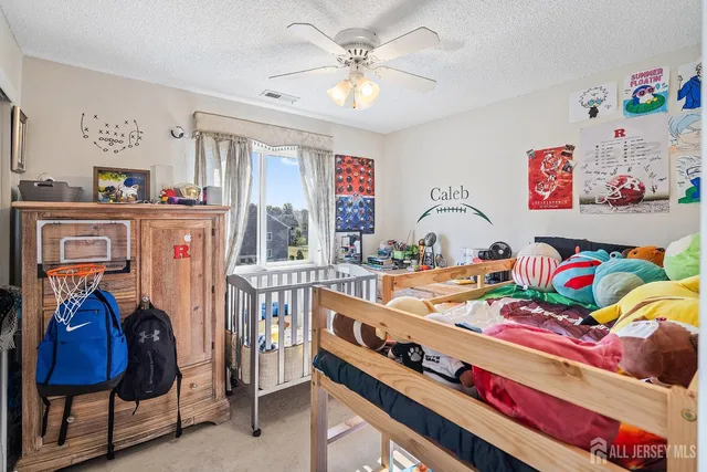 a kids bedroom with furniture and a chandelier fan