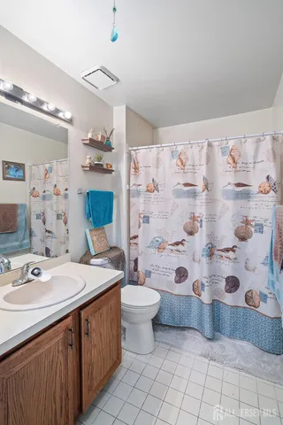 a bathroom with a sink a toilet and shower curtain