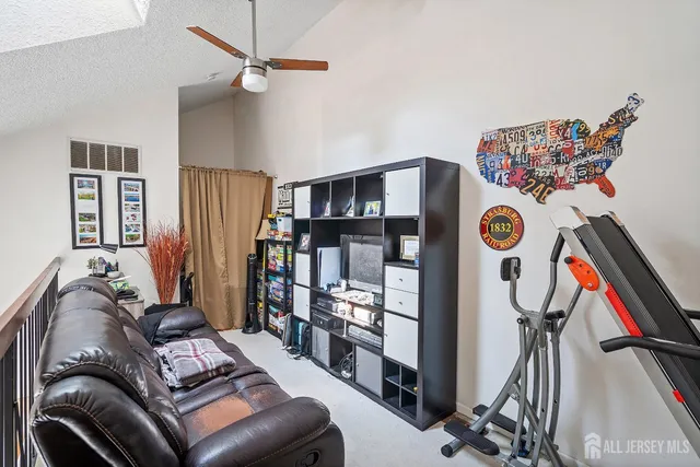 a living room with furniture gym equipment and a chandelier