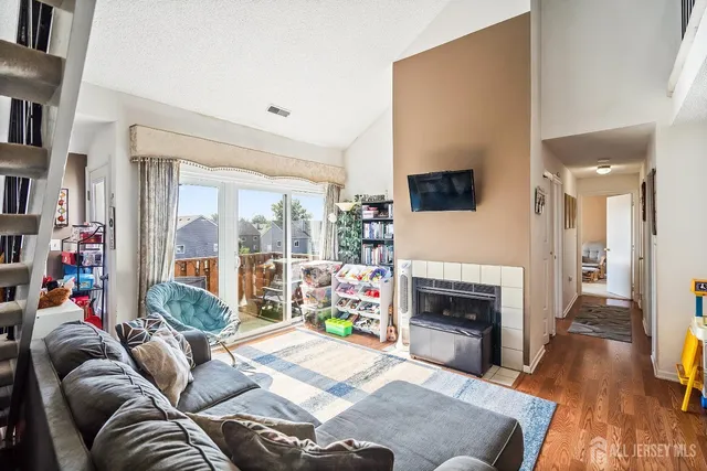 a living room with furniture a flat screen tv and a fireplace