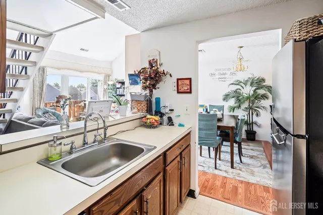 a kitchen with a sink a counter and a living room view