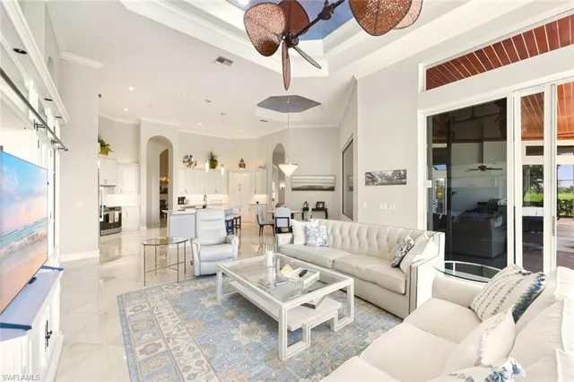 a living room with furniture a chandelier and a large window