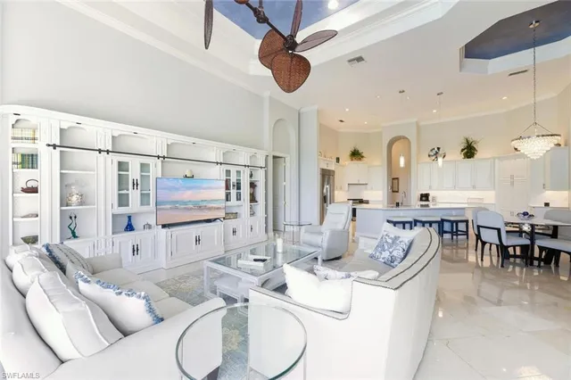 a living room with furniture kitchen view and a large window