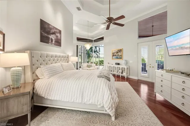 a bedroom with a large bed and a flat tv screen on dresser