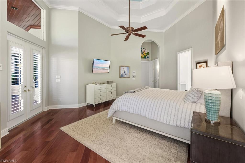 396 Terracina Way Naples, FL 34119 - Photo 34 of 50 Bedroom with a high ceiling, french doors, dark wood-style flooring, access to exterior, and a raised ceiling
