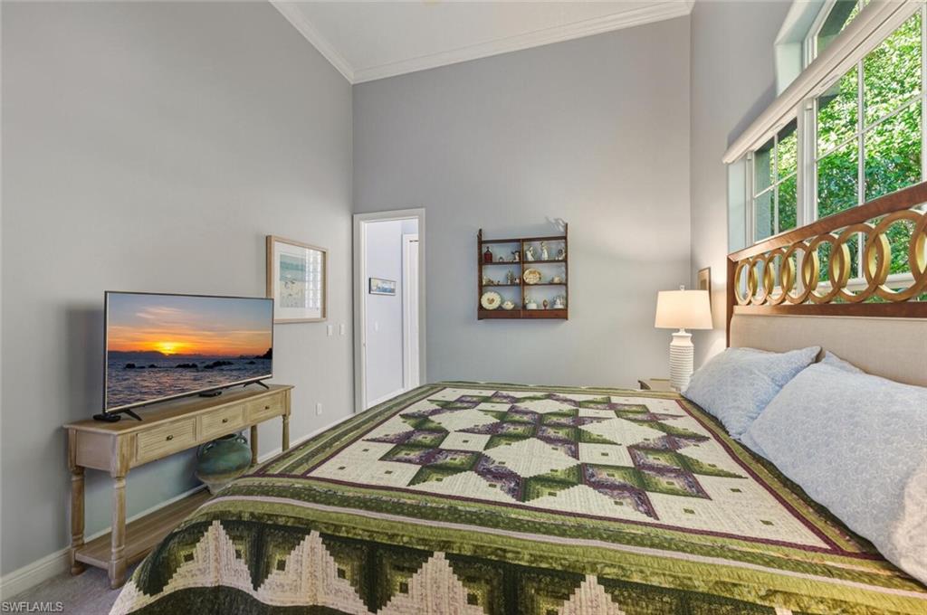 396 Terracina Way Naples, FL 34119 - Photo 46 of 50 Carpeted bedroom with ornamental molding and a high ceiling