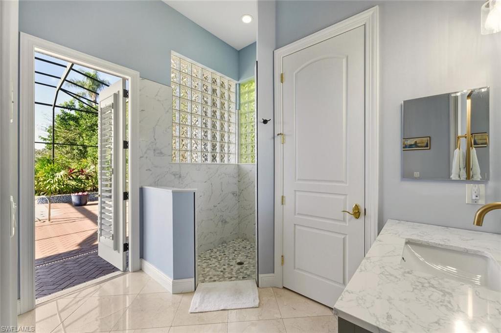 396 Terracina Way Naples, FL 34119 - Photo 47 of 50 Full bathroom featuring a marble finish shower, vanity, and plenty of natural light