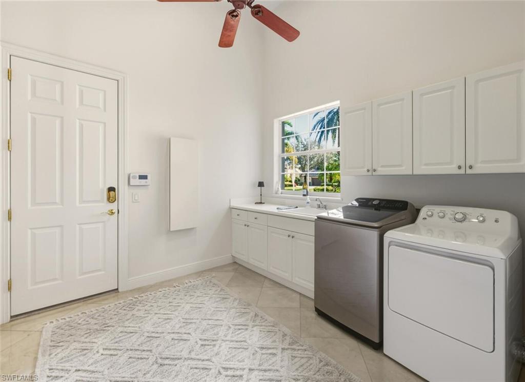 396 Terracina Way Naples, FL 34119 - Photo 48 of 50 Laundry room with cabinet space, separate washer and dryer, light tile patterned floors, ceiling fan, and a high ceiling