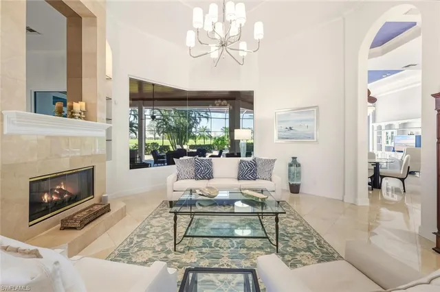 a living room with furniture a fireplace and a large window