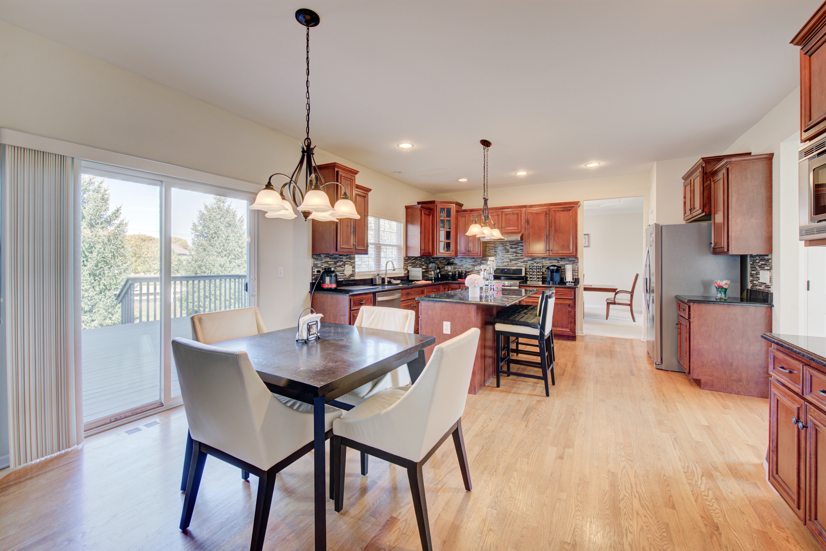 24520 Rockefeller Court Plainfield, IL 60544 - Photo 11 of 57 a view of a dining room and livingroom with furniture wooden floor a chandelier