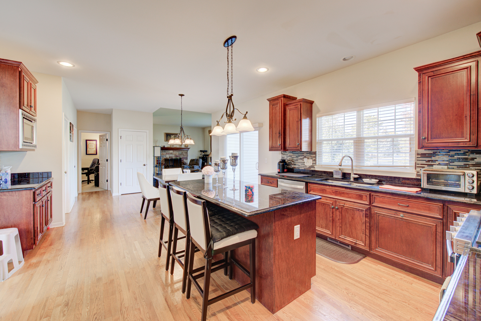 24520 Rockefeller Court Plainfield, IL 60544 - Photo 16 of 57 a kitchen with stainless steel appliances granite countertop a kitchen island a stove a table and chairs in it