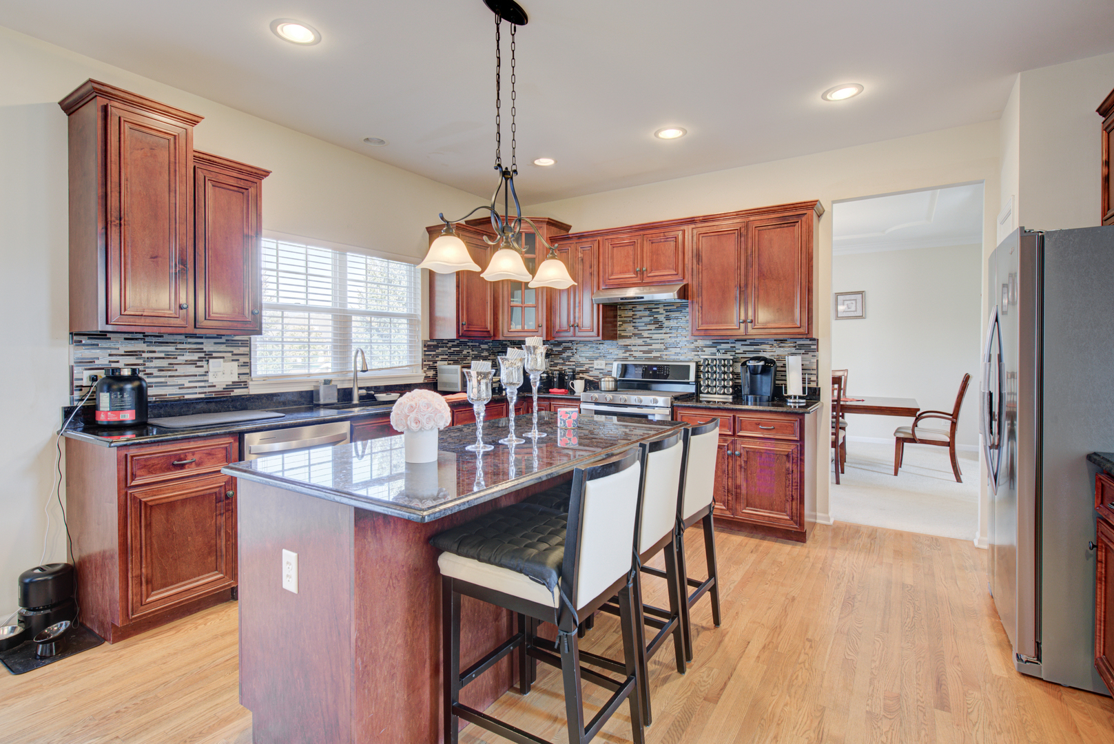 24520 Rockefeller Court Plainfield, IL 60544 - Photo 10 of 57 a kitchen with stainless steel appliances granite countertop a stove top oven a refrigerator a sink and chairs