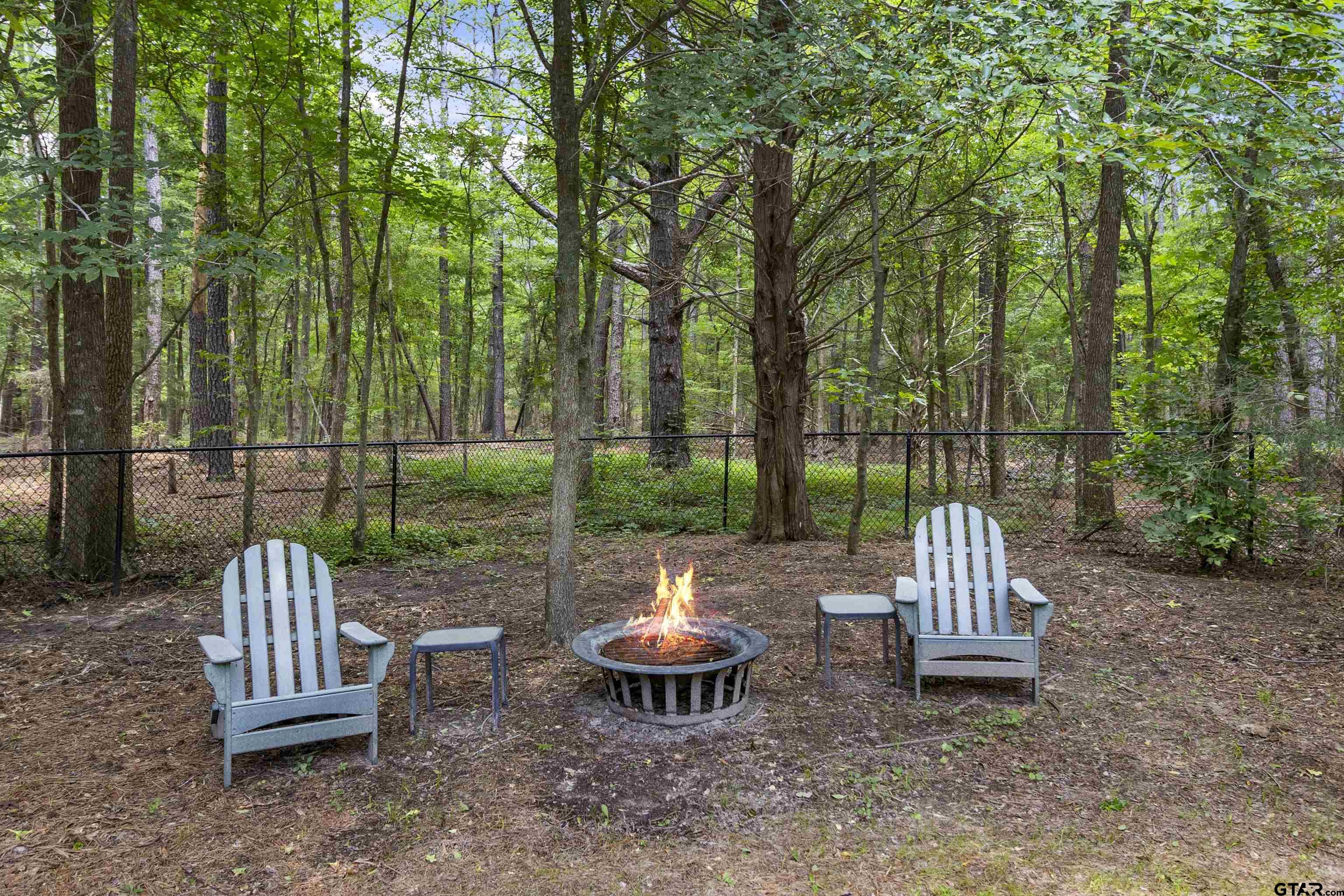21755 Pagosa Ranch Road Bullard, TX 75757 - Photo 11 of 37 a view of a chair and fire pit in the backyard