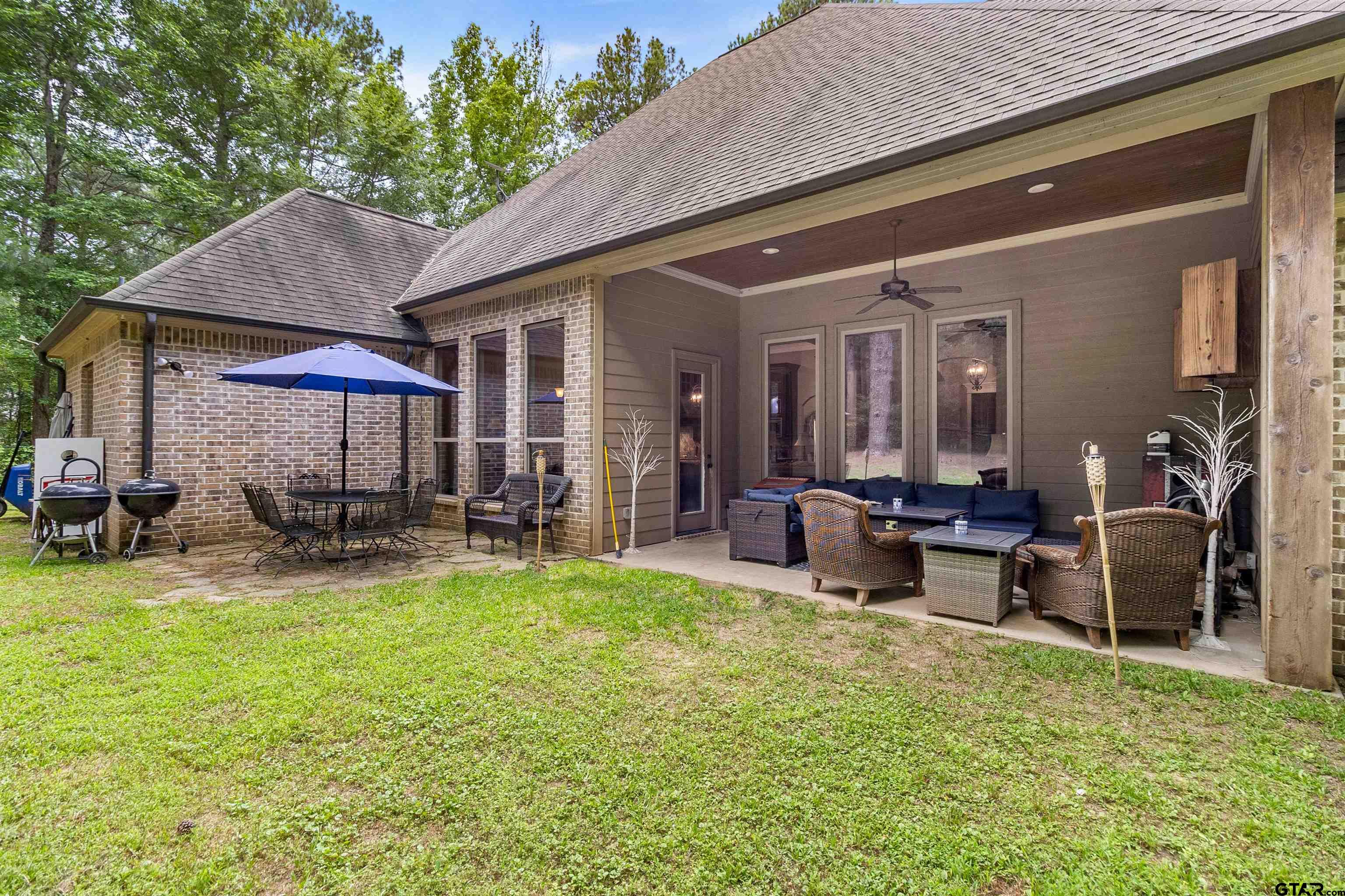 21755 Pagosa Ranch Road Bullard, TX 75757 - Photo 12 of 37 a view of a house with a patio and a yard