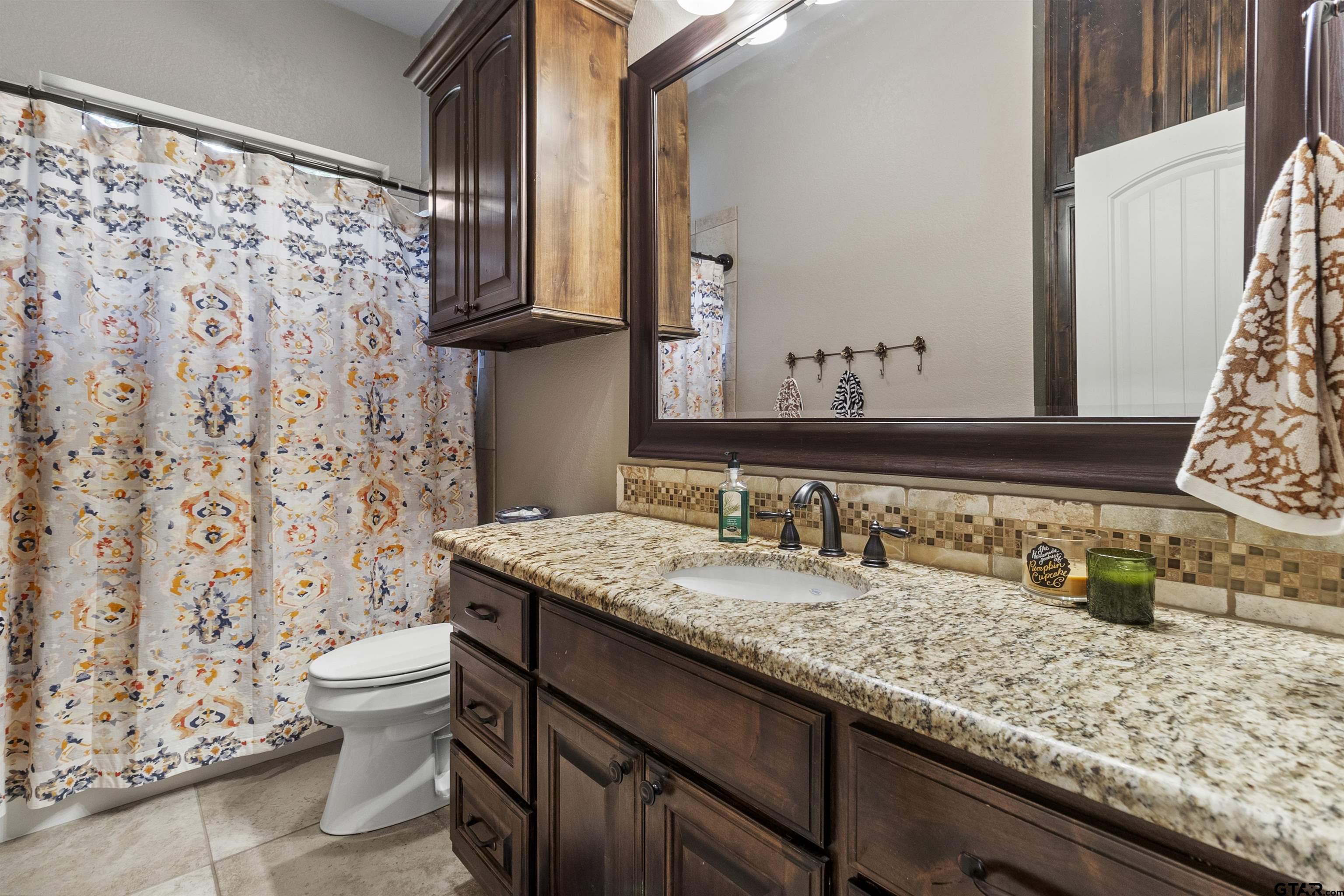 21755 Pagosa Ranch Road Bullard, TX 75757 - Photo 23 of 37 a bathroom with a granite countertop sink and a mirror