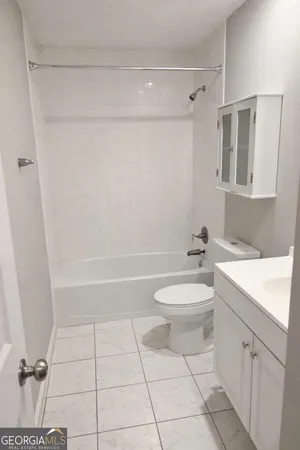 a bathroom with a toilet a sink a mirror and vanity