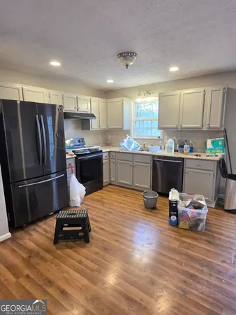 a kitchen with a refrigerator and a stove