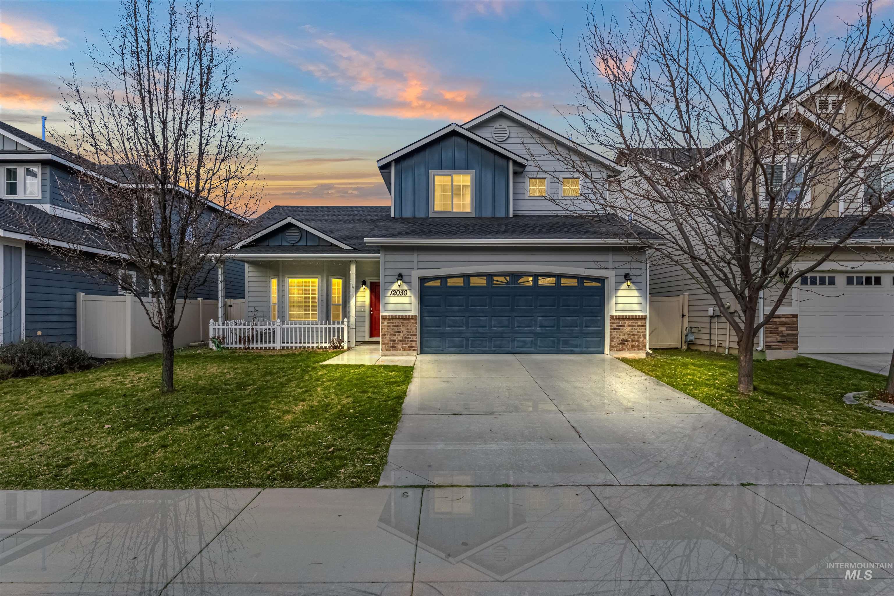 Traditional home featuring board and batten siding, a porch, brick siding, driveway, and an attached garage