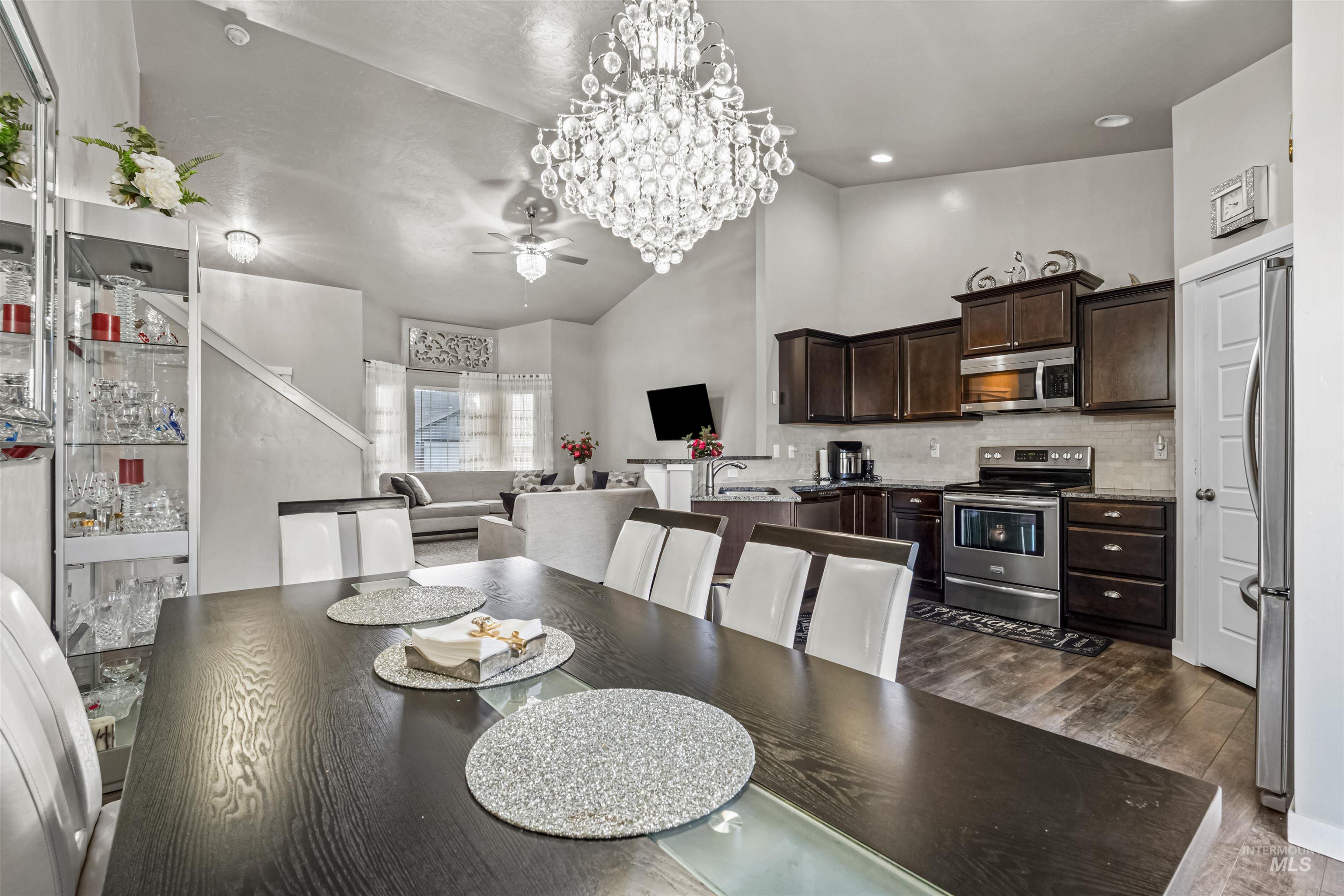 12030 West Abram Street Boise, ID 83713 - Photo 11 of 26 Dining room featuring hanging lights, dark wood-style floors, ceiling fan, and vaulted ceiling