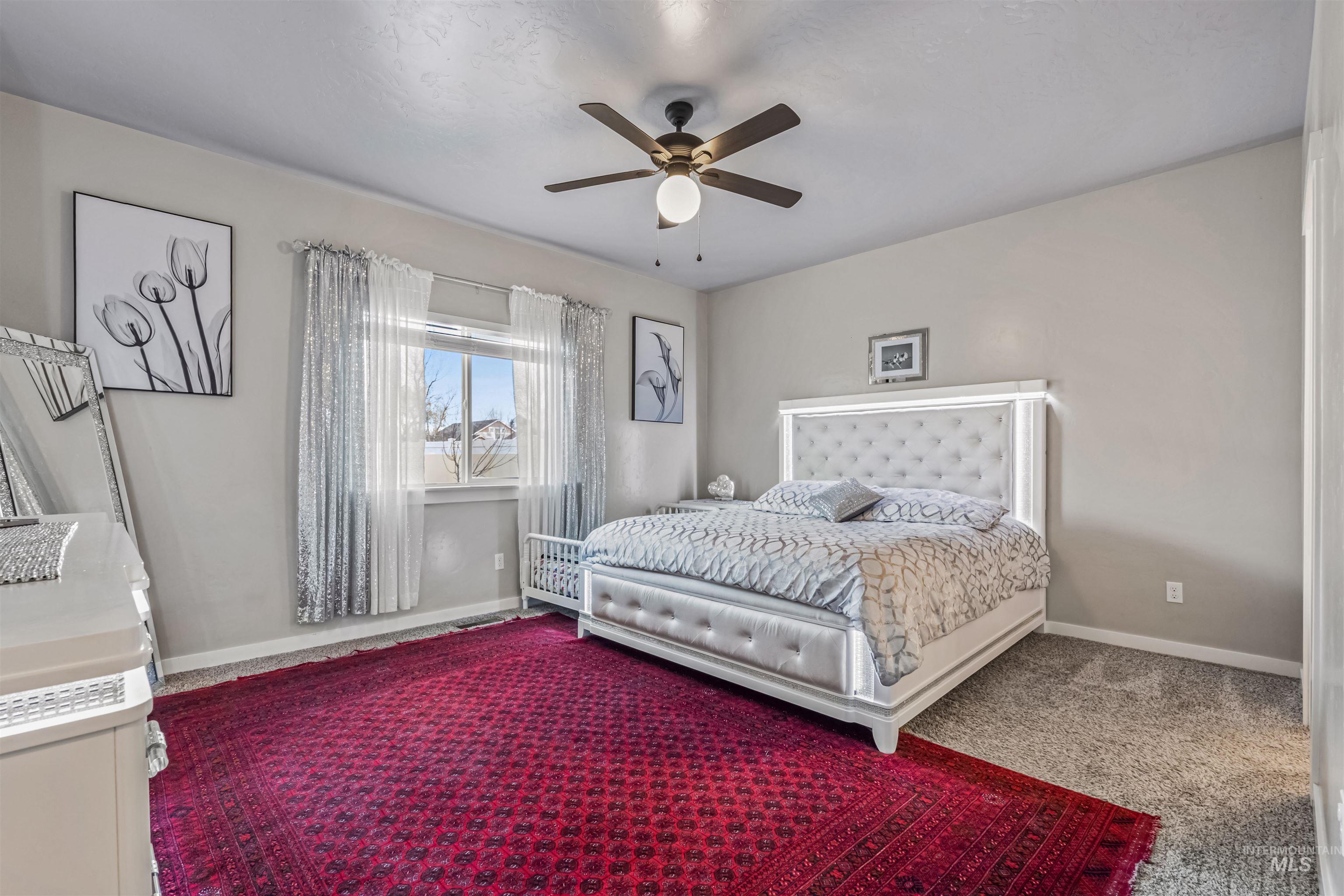 12030 West Abram Street Boise, ID 83713 - Photo 15 of 26 Carpeted bedroom with baseboards and a ceiling fan